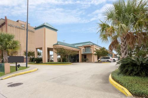 a building with palm trees in front of a street at Rodeway Inn & Suites New Orleans Gentilly in New Orleans