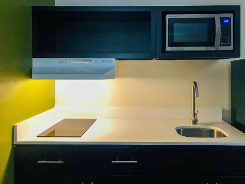 a kitchen with a sink and a microwave at Quality Inn & Suites Lake Charles South in Lake Charles