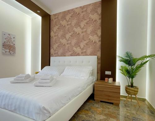 a bedroom with a white bed and a potted plant at SIS HOUSE Apartment - Deluxe Apartment in Anzio City Center, 100m from the Sea in Anzio