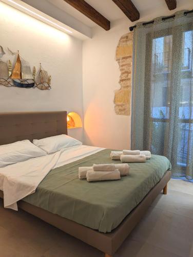 a bedroom with a bed with towels on it at Casa di Leda 3 in Cagliari