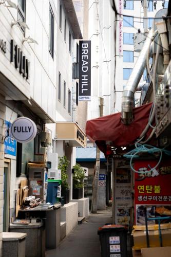 an alley in a city with signs on buildings at Bread Hill Hotel Jongno in Seoul