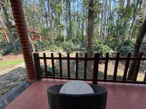 a trash can sitting on a porch with a fence at Coffee Grove Resort in Chikmagalūr
