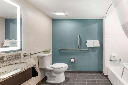 a bathroom with a white toilet and a blue wall at Sleep Inn Olathe - Kansas City in Olathe