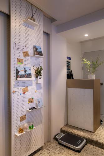 a room with a white pegboard wall with a cell phone at Bread Hill Hotel Jongno in Seoul