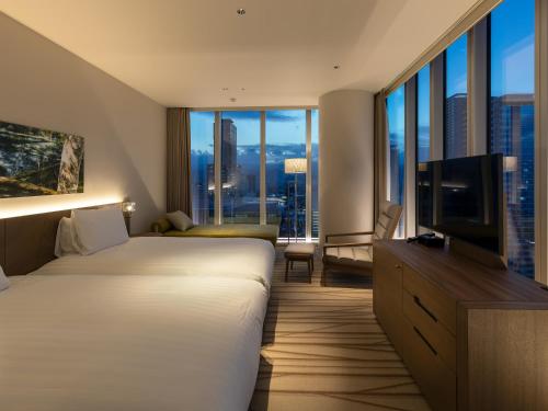 a hotel room with two beds and a flat screen tv at SAPPORO HOTEL by GRANBELL in Sapporo