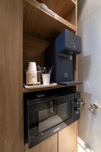 a black microwave oven sitting on top of a cabinet at Bread Hill Hotel Jongno in Seoul