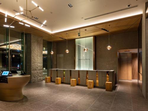 a lobby with a row of benches and a table at SAPPORO HOTEL by GRANBELL in Sapporo