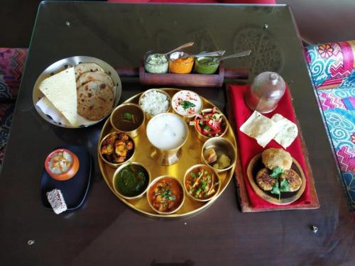 a table topped with different types of food on a table at HOLYWATER Hotel by Ganga Kinare #150 mts from Ganga Ghat Rishikesh in Rishīkesh