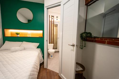 Un dormitorio con una cama blanca y una pared verde. en Casa42, en Estación Pamplona