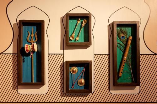 a group of four wooden clocks on a wall at HOLYWATER Hotel by Ganga Kinare #150 mts from Ganga Ghat Rishikesh in Rishīkesh