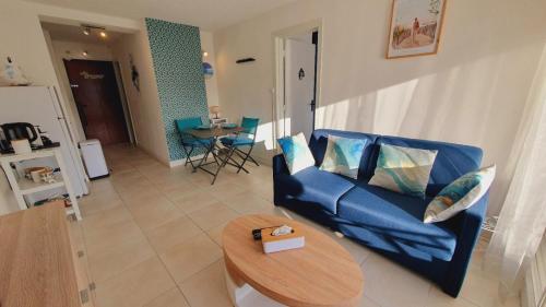 a living room with a blue couch and a table at T2 West CITY Parking Clim Wifi 4pers - ROSSIconciergerie - Linge inclus in La Grande-Motte