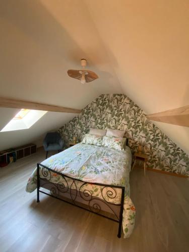 une chambre avec un lit dans un grenier dans l'établissement La Petite Sancerroise, à Jars