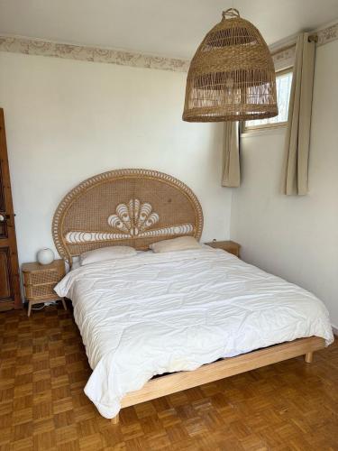 une chambre avec un grand lit avec une tête de lit en rotin dans l'établissement maison de charme piscine au bord de mer, à Cagnes-sur-Mer