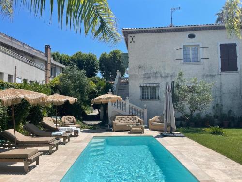 - une piscine avec des chaises et des parasols à côté d'une maison dans l'établissement maison de charme piscine au bord de mer, à Cagnes-sur-Mer
