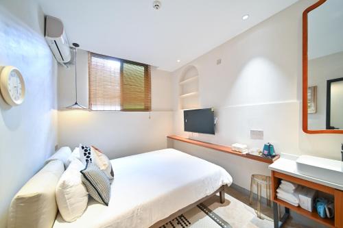a small room with a bed and a sink at 鼓浪屿古巷别苑旅馆 in Xiamen