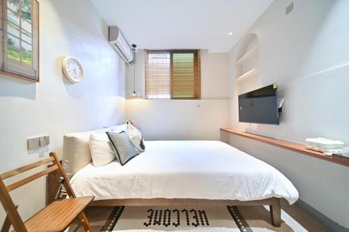 a small bedroom with a bed and a tv at 鼓浪屿古巷别苑旅馆 in Xiamen