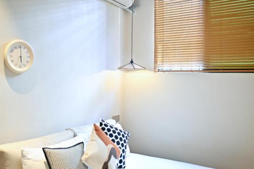 a bedroom with a window with a clock on the wall at 鼓浪屿古巷别苑旅馆 in Xiamen