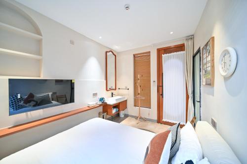 a bedroom with a bed and a sink and a tv at 鼓浪屿古巷别苑旅馆 in Xiamen