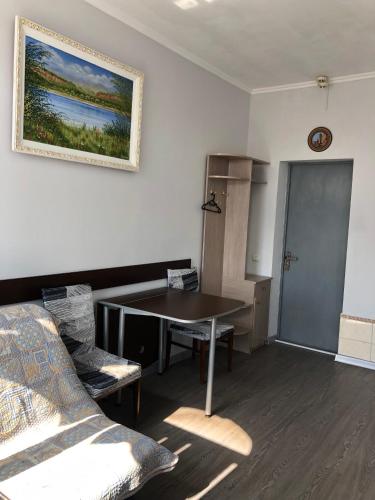 a room with a table and chairs and a painting on the wall at Готель Оазис in Chernivtsi