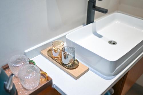 a bathroom sink with glasses on a tray next to it at 鼓浪屿古巷别苑旅馆 in Xiamen