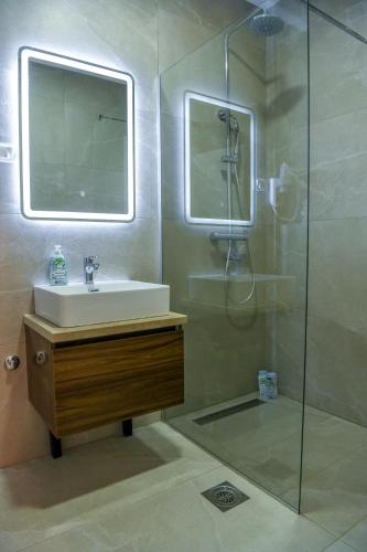 a bathroom with a sink and a glass shower at Vila sa bazenom Vrnjačka Idila in Vrnjačka Banja
