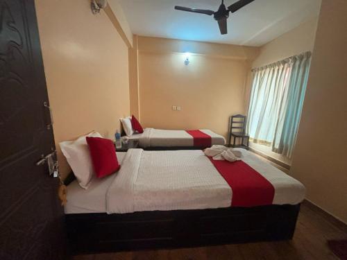 two beds in a hotel room with a window at Hotel Fewa Lake View in Pokhara