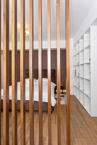 a wooden crib in a bedroom with white shelves at Panoramic Studio Oradea 2 in Oradea