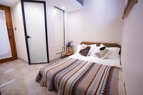 a bedroom with a bed with white sheets and pillows at 鼓浪屿古巷别苑旅馆 in Xiamen