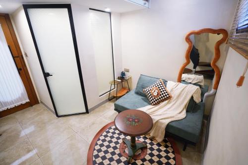 a living room with a green couch and a mirror at 鼓浪屿古巷别苑旅馆 in Xiamen