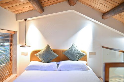 a bedroom with a white bed with blue pillows at 鼓浪屿古巷别苑旅馆 in Xiamen
