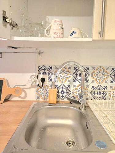 un comptoir de cuisine avec un évier dans une cuisine dans l'établissement Studio neuf avec terrasse à Yerres, 200m de la gare, à Yerres