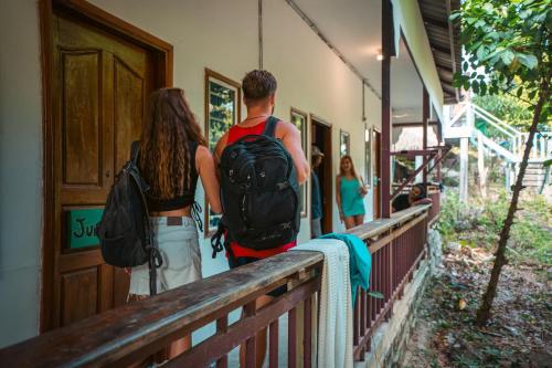a man and woman with backpacks walking into a building at Nest Jungle in Koh Rong
