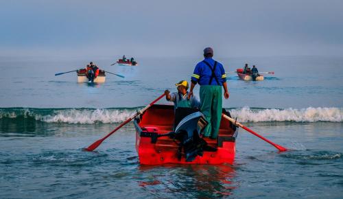 a group of people in a red boat in the water at Dankbaar Holiday Home in Paternoster