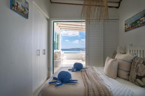 two blue stuffed animals sitting on a bed in a bedroom at Dankbaar Holiday Home in Paternoster