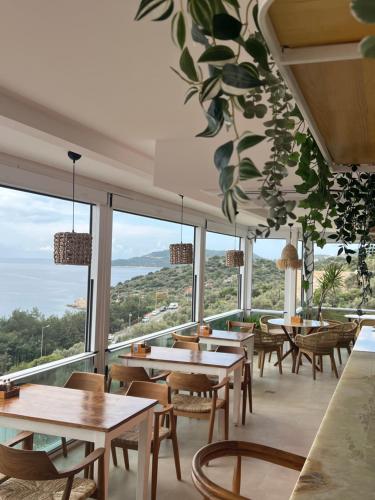 a restaurant with tables and chairs and large windows at Hideaway in Kas
