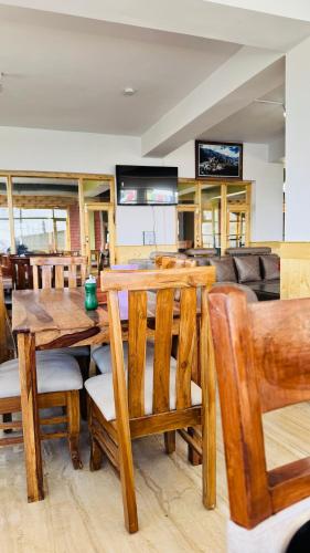 a dining room with a wooden table and chairs at Hotel Spiti House in Kaza