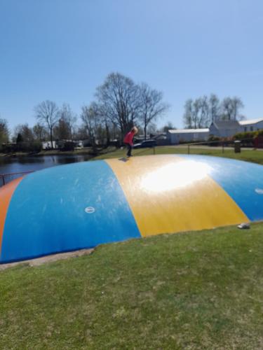 a person riding a skateboard on a ramp with an umbrella at Chalet Makkum C99B met prive gelegen tuin aan het water in Makkum