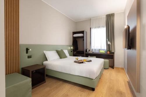 a hotel room with a bed with a tray of food on it at Energy Park Hotel in Vimercate