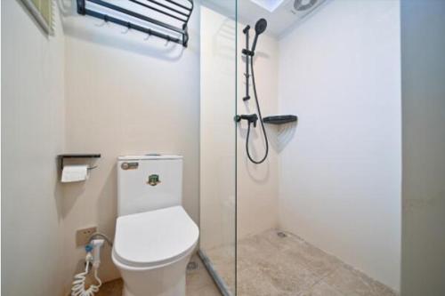 a bathroom with a toilet and a glass shower stall at 鼓浪屿古巷别苑旅馆 in Xiamen