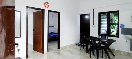 una stanza con tavolo e sedie e una camera da letto di Mamalakandam Hill house - Diya homestay a Mamalakandam