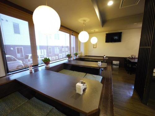 a living room with a table and a large window at Hotel Route-Inn Court Yamanashi in Yamanashi