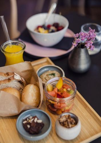 a table topped with a tray of food with bread and vegetables at DER*ADLER Apartments in Schoppernau