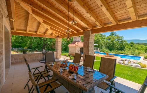 a patio with a table and chairs and a pool at Villa Drazana - Makarska by Villas Guide in Perići
