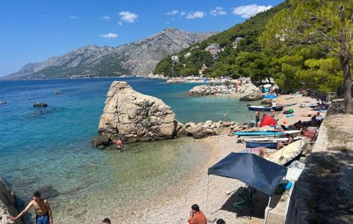 a beach with a bunch of people in the water at Villa Drazana - Makarska by Villas Guide in Perići