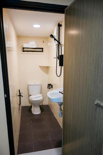 a bathroom with a toilet and a sink at Orkid Inn Kajang in Kajang