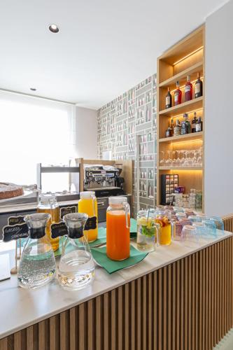 a counter with a bunch of glasses of orange juice at Energy Park Hotel in Vimercate