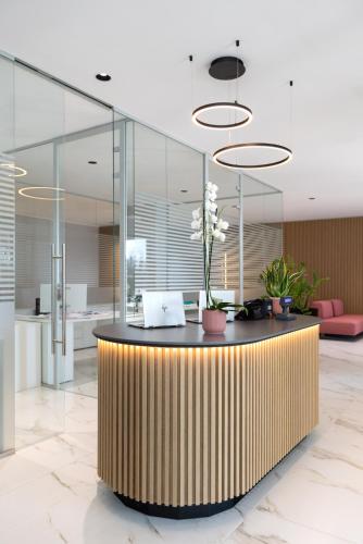 a lobby with a reception desk with glass walls at Energy Park Hotel in Vimercate