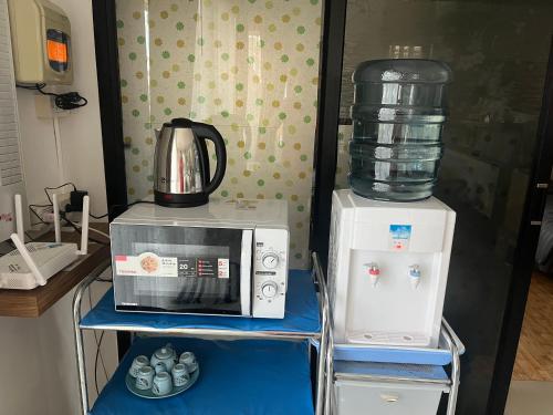 a kitchen with a microwave and a blender on a shelf at บ้านสวนรัญจวนสาขาสุราษฎร์ธานี in Ban Huai Chiat