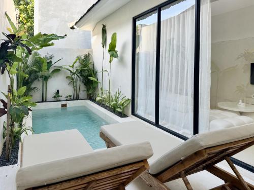 a small swimming pool in the middle of a room with a window at The Ulu Hills in Uluwatu