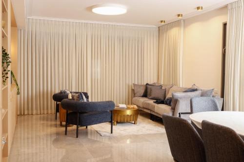 ein Wohnzimmer mit einer Couch und Stühlen und einem Tisch in der Unterkunft Luxurious and spacious pentahouse in Beit Shemes in Bet Schemesch